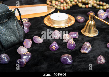 Rune sparsi per la divinazione con gli attributi di magica sul tavolo Foto Stock