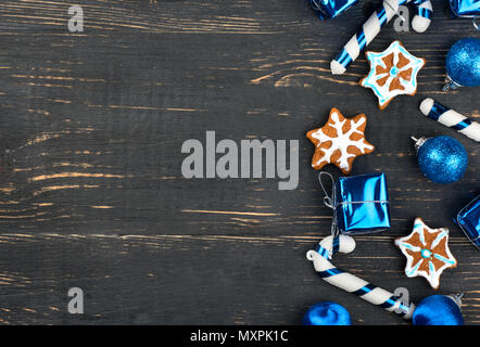 Sparse in casa gingerbread cookies con decorazioni di Natale su un vuoto sullo sfondo di legno Foto Stock