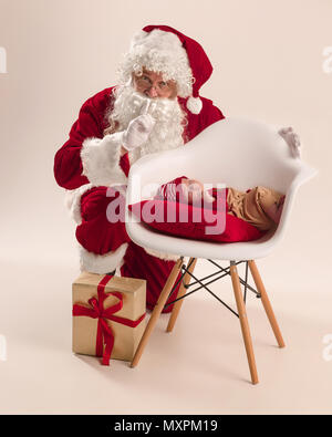 Ritratto di natale di carino piccolo neonato ragazza, vestito in abiti di natale, studio shot, Inverno tempo Foto Stock