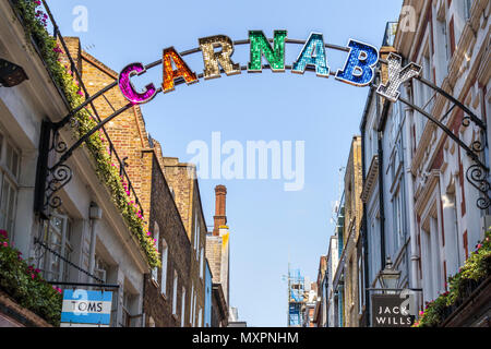 Scintillante e colorati di firmare all'entrata dell'iconico Carnaby Street nel West End Carnaby quartiere dello shopping, Soho, Londra W1 in una giornata di sole Foto Stock