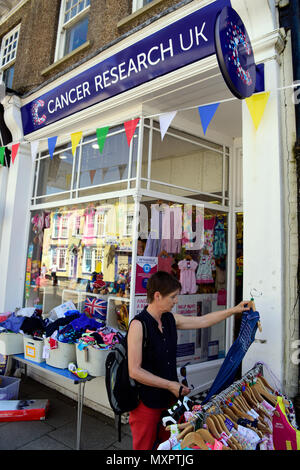 Navigazione donna indumenti di seconda mano sezione del Cancer Research UK carità shop, Petersfield, Hampshire, Regno Unito. Foto Stock