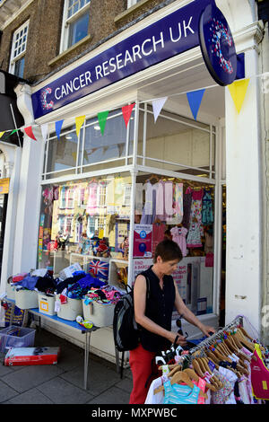 Navigazione donna indumenti di seconda mano sezione del Cancer Research UK carità shop, Petersfield, Hampshire, Regno Unito. Foto Stock