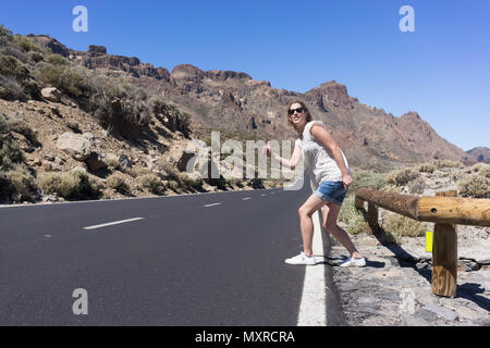 Donna di agganciare una vita su una strada di montagna Foto Stock