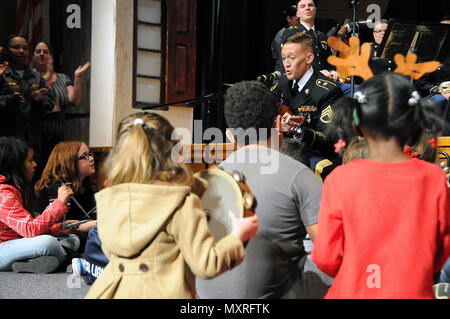 I bambini partecipano in un sing-un-lungo con Staff Sgt. Giuseppe giovani. Young è assegnato per gli Stati Uniti Esercito della riserva 319Army Band fuori di Fort Totten, New York. I giovani e gli altri membri del 319giocato con la 78a banda armata durante la loro vacanza concerto 3 Dicembre in Pemberton, New Jersey. Ulteriori informazioni circa la 78a può essere trovato sulla loro pagina di Facebook. Foto Stock