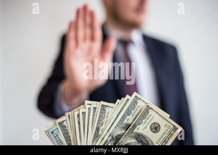 Tangenti e corruzione, offerto denaro per un imprenditore in un vestito, non vuole prendere loro, tenere mani verticale Foto Stock