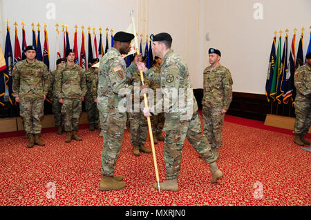 Col. Benjamin C. Jones, a destra del centro, U.S. Presidio militare di Ansbach commander, passa la sede e sede di distacco a guidon Capt. Olufemi O. Apata, incoming distacco commander, 6 dicembre 2016, presso il Von Steuben centro comunitario in Ansbach, Germania. Il cap. H. Matteo Sperber, secondo da destra, aveva ordinato USAG Ansbach's HHD per gli ultimi due anni. (U.S. Esercito Foto di Georgios Moumoulidis, TSC Ansbach) Foto Stock