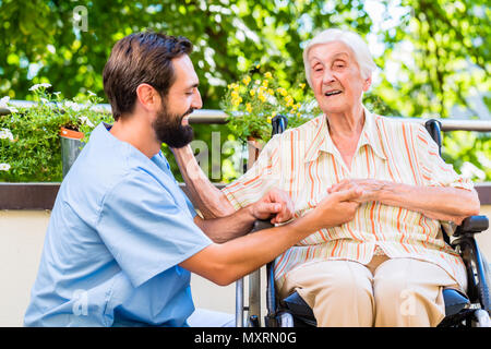 Infermiera geriatrica tenendo la mano della vecchia donna in casa di riposo Foto Stock