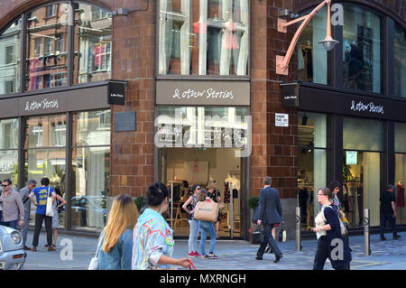 I turisti e gli amanti dello shopping a piedi passato l'H&M Group abbigliamento donna rivenditore & altre storie, in Covent Garden di Londra. Foto Stock