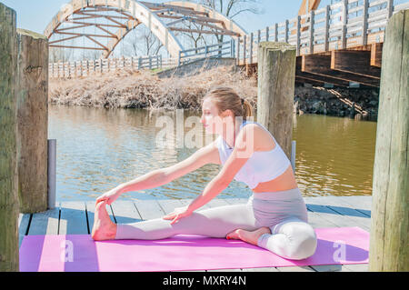 Lo Yoga. Giovane donna a praticare yoga Janu Sirsasana pongono. Concetto di calma e di meditazione. Foto Stock