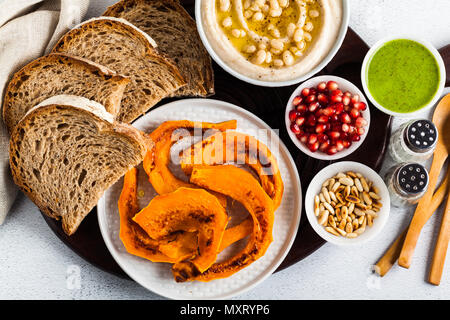Antipasto vegano snack da hummus di bianco fagioli cannellini e zucca cotta al forno con pane di segale su una scheda che serve. Appena il grande cibo Foto Stock