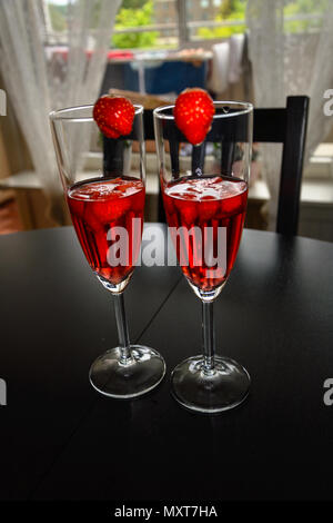 Win bicchieri da vino rosso e fragole Foto Stock
