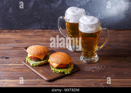 Foto di due hamburger, bicchieri di birra Foto Stock