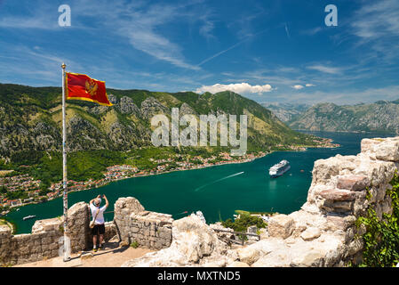 La bandiera nazionale della Repubblica del Montenegro e la vista sulla Baia di Kotor dal monte Lovcen. Montenegro. Foto Stock