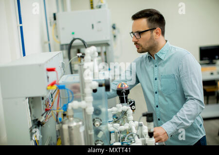 Bel giovane uomo nel laboratorio elettronico Foto Stock