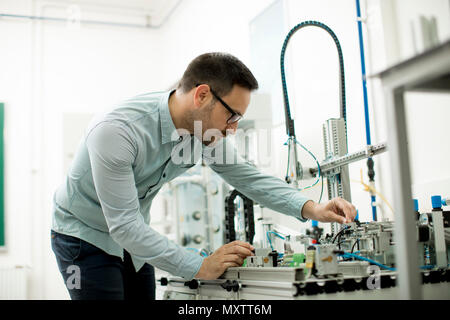 Bel giovane uomo nel laboratorio elettronico Foto Stock