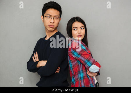 Immagine di orinato giovani asiatici amare giovane standing isolate su muro grigio Sfondo litigare. Foto Stock