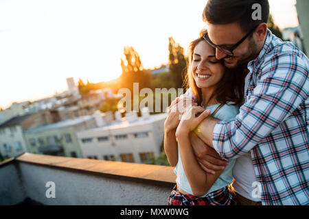 Ritratto di un amore giovane abbracciando la donna da dietro Foto Stock