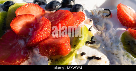 Mascarpone torta pavlova con fragole, kiwi, mirtillo. La crema dessert Foto Stock