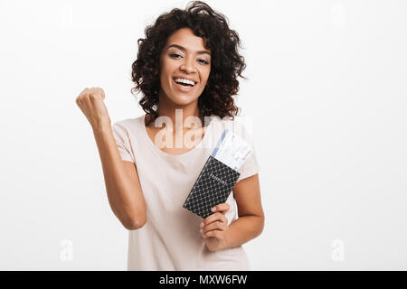 Ritratto di un felice giovani afro american donna holding passaporto con i biglietti di volo isolate su sfondo bianco Foto Stock