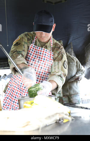 Spc. Nicholas Jerman, 364 Expeditionary Supporto comando, prepara il cibo per il Yama Sakura 71 Iron Chef battaglia concorrenza sul Camp Kengun, Giappone, Dicembre 5, 2016. Foto Stock