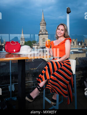 La moda e lo stile di vita di blogger Andreea Rasclescu presso il bar sul tetto in Oxford, The Varsity Club, bevendo un bicchiere di colore arancione di Aperol per abbinare il suo Outfit Foto Stock