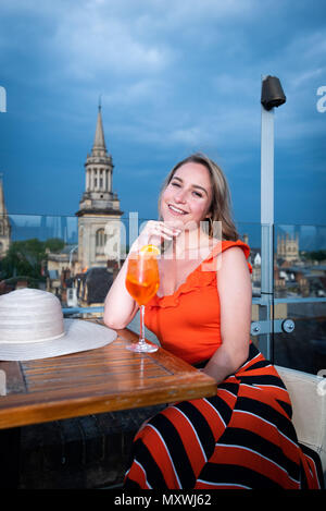 La moda e lo stile di vita di blogger Andreea Rasclescu presso il bar sul tetto in Oxford, The Varsity Club, bevendo un bicchiere di colore arancione di Aperol per abbinare il suo Outfit Foto Stock