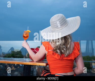 La moda e lo stile di vita di blogger Andreea Rasclescu presso il bar sul tetto in Oxford, The Varsity Club, bevendo un bicchiere di colore arancione di Aperol per abbinare il suo Outfit Foto Stock