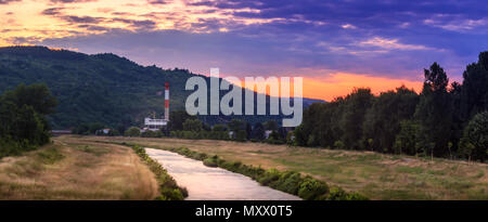 Vista panoramica del movimento sfocate Nisava fiume di Pirot e distante il vecchio stabilimento durante la vivace, tramonto colorato Foto Stock