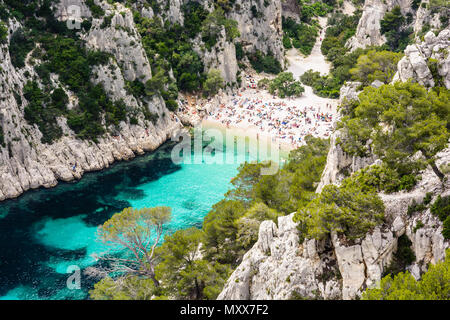 Vista da sopra del di calanque En-Vau, un hard-to-raggiungere stretta insenatura naturale con spiaggia di sabbia bianca vicino a Marsiglia e Cassis, con persone sunb Foto Stock