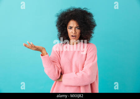 Immagine colorata closeup di indignato donna con acconciatura afro alzare la mano e esprimendo malinteso isolate su sfondo blu Foto Stock
