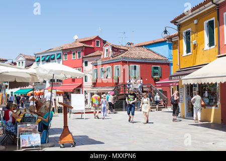 Colorati negozi e ristoranti in via Baldassarre Galuppi, Isola di Burano, Venezia, Veneto, Italia, la strada principale che attraversa il paese. Attrac turistica Foto Stock