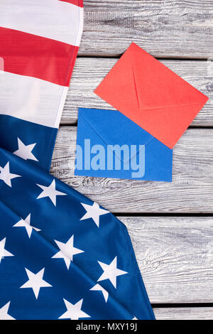 Bandiera americana e due buste colorate. Stati Uniti d'America patriottica bandiera e le buste sul vecchio sfondo di legno. Foto Stock