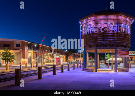 Santa Fe Railyard e water tower illuminata di notte, con attraversamento ferroviario gates scendendo nel Nuovo Messico, Stati Uniti d'America. Foto Stock