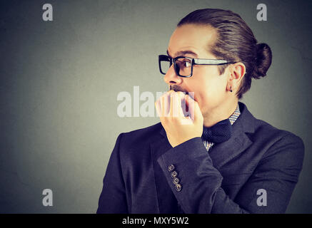 Preoccupato ansioso giovane il suo mordere le unghie cercando di lato Foto Stock