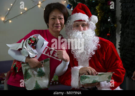 Un operatore sanitario in posa per una foto con Babbo Natale durante una visita natalizia al Reimei no Sato home per disabili 16 dic in Ishikawa, Okinawa, in Giappone. Reimei no Sato fornisce assistenza per adulti con offerte quotidiane esigenze di soggiorno. Durante la visita, i membri del servizio da Camp Hansen consegnato Doni di natale forniti dagli ufficiali di Marina Club di coniugi e speso tempo diffondere allegria natalizia con i residenti. I marines sono con xii reggimento Marine, terza divisione Marine, III Marine Expeditionary Force. (U.S. Marine Corps foto di Cpl. Janessa K. Pon) Foto Stock