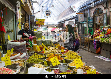 9 maggio 2018 i clienti lo stoccaggio su diversi tipi di frutta, spezie e verdure presso la trafficata Mahane Yehuda coperto street market in Jerusalem Israel Foto Stock