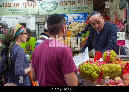 9 maggio 2018 i clienti lo stoccaggio su diversi tipi di frutta, spezie e verdure presso la trafficata Mahane Yehuda coperto street market in Jerusalem Israel Foto Stock