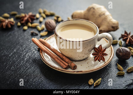 Tradizionale bevanda indiana - masala tè alle spezie con nero su sfondo di pietra Foto Stock