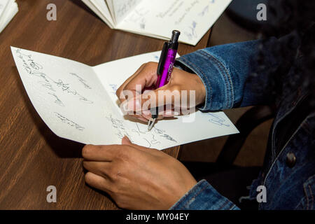 Airman Miranda Loera, 4° Fighter Wing Public Affairs fotoreporter, segni di cartoline in Goldsboro, North Carolina, prima di uscire per visitare con i residenti del North Carolina State veterani Home in Kinston, North Carolina, Dic 24, 2016. Circa 45 volontari da Seymour Johnson Air Force Base, Goldsboro Elk Lodge #139 e Wayne County passata fuori a mano goody borse e carte di Natale per i veterani durante la vacanza visita. (U.S. Air Force foto di Airman Shawna L. Keyes) Foto Stock