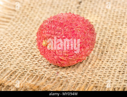 Deliziosa lychee frutta in guscio su un letto di sacco close up Foto Stock