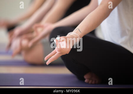 Giovane donna sportiva la pratica dello yoga, in seduta in Lotus pongono, con gesto mudra, lavorando fuori, piscina vicino, studio di yoga. Mindfulness, benessere, abbiamo Foto Stock