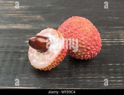 Litchi freschi frutti con un compagno al buio su un tavolo Foto Stock