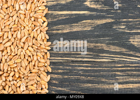 Sparse in grani di grano su un vuoto sullo sfondo di legno Foto Stock