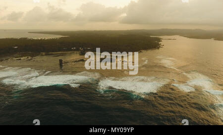 Punto di vista nell'oceano al Cloud Nine punto surf al tramonto, Siargao island , Filippine. Vista aerea sollevata passerella in legno per surfisti di attraversare la barriera corallina di siargao island al cloud 9 surf break sull isola di Mindanao. Isole Siargao famoso surf break cloud 9. Volare sopra il mare blu nelle acque azzurre della laguna. Foto Stock