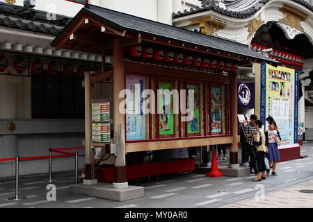 Visitatori guardare un cartellone di fronte a Tokyo's Kabuki-za teatro kabuki che dispone di informazioni sulle prestazioni. (Maggio 2018) Foto Stock
