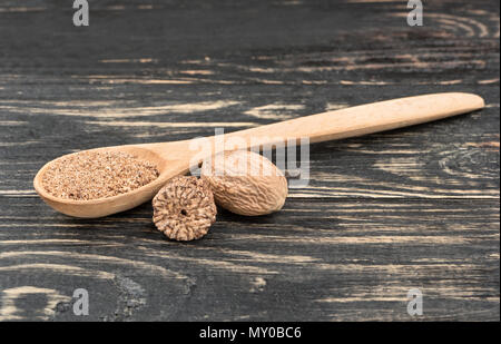 Noce moscata in polvere in cucchiaio su sfondo di legno Foto Stock
