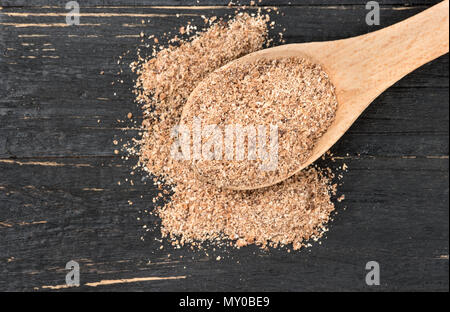 Noce moscata in polvere in cucchiaio su sfondo di legno, vista dall'alto Foto Stock