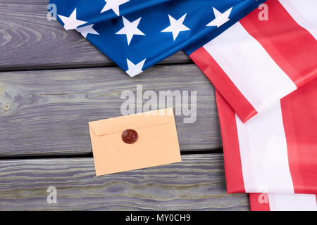 Busta di artigianato e bandiera americana. Bandiera degli Stati Uniti ripiegato su sfondo di legno, vista dall'alto. Messaggio di saluto con il Giorno di Indipendenza. Foto Stock