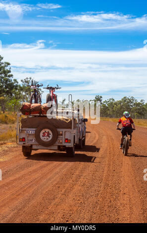 Un ciclista in sella a una fatbike e a 4 ruote motrici del veicolo di supporto nel Gibb Challenge 2018 sulla Gibb River Road WA Kimberley Australia Foto Stock