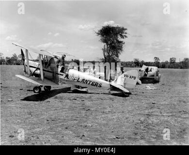 Piano di semi di caricamento in corrispondenza Kiddell pianure, dicembre 1962. De Havilland Australia DH-82A Tiger Moth VH-APH fu costruito in mascotte, NSW nel settembre 1940 per la Royal Australian Air Force e portato RAAF serial 17-116. È servito con il No.7 elementare di Flying Training School in Tasmania e andò in giacenza alla fine di WW2. È stato venduto ad un acquirente privato nel 1946 e registrata come VH-APH con Queensland battenti Servizi nel 1957. È stato venduto a Airplanters di Bundaberg e azionato in tale regione di eseguire il seeding aeree e altri lavori agricoli fino al momento del pensionamento nel 1966. Essa è stata restaurata nel 1989 e mi Foto Stock